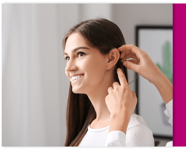 Hearing specialist helping a patcient with her hearing aid